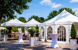 Weiße Partyzelte und Stehtische im Freien